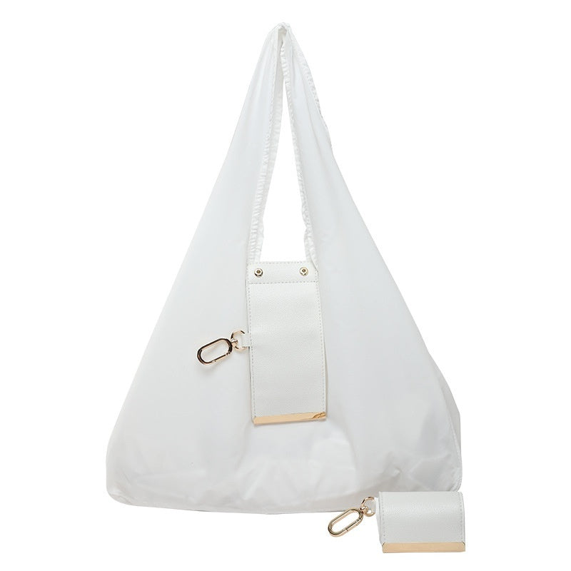 White handbag with gold accents on a white background