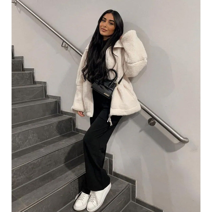 Woman in a white coat standing on a staircase