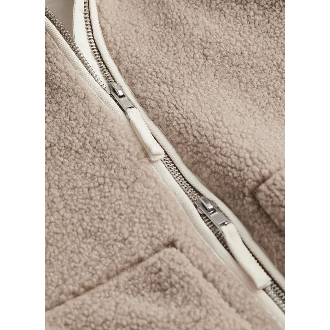 Close-up of a beige fleece jacket with a zipper
