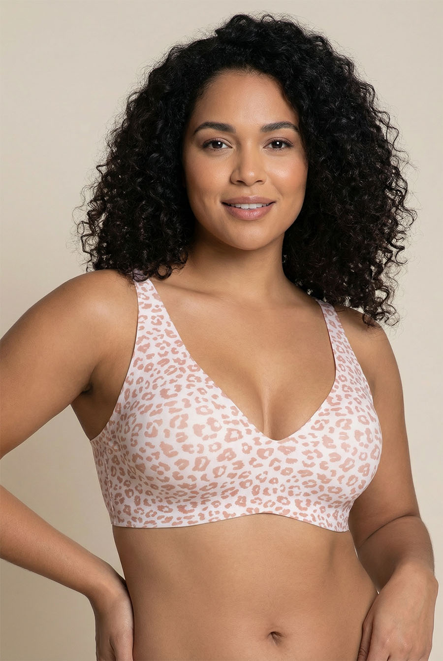 Woman wearing a leopard print bralette against a beige background