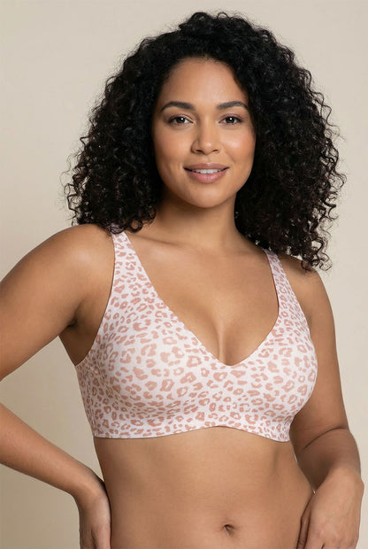 Woman wearing a leopard print bralette against a beige background
