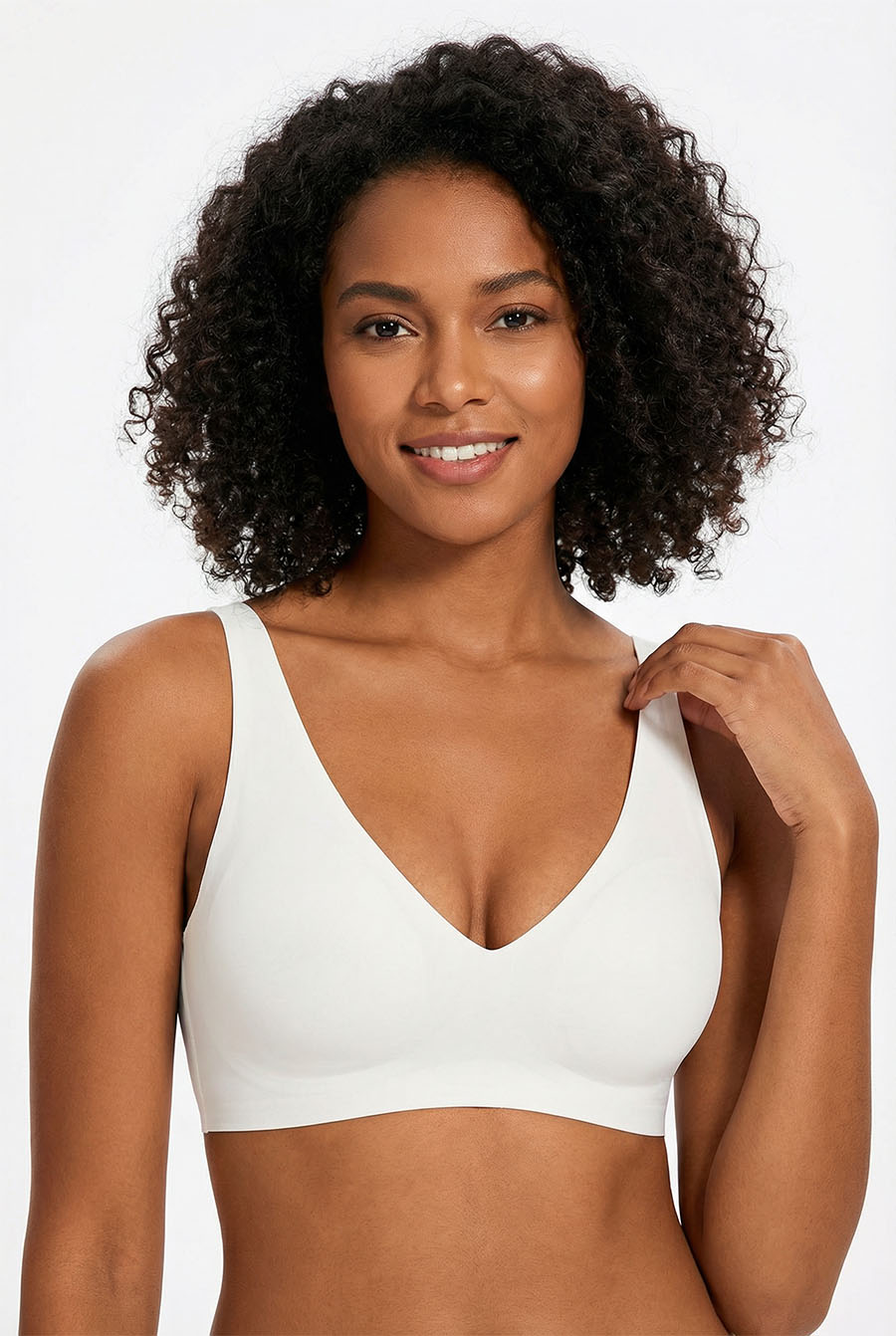 Woman wearing a white sports bra against a plain background
