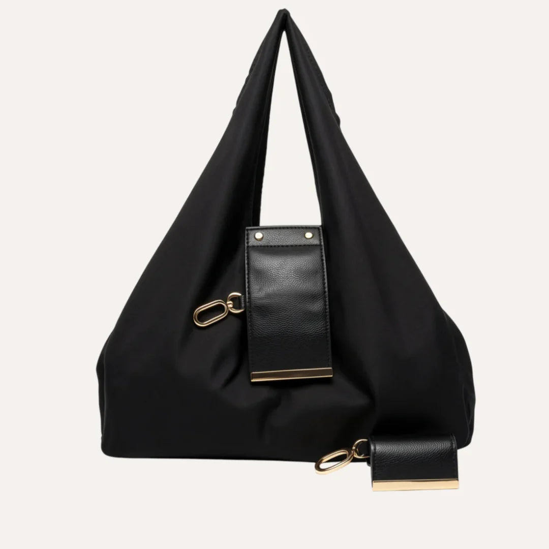 Black handbag with a smaller attached bag on a white background