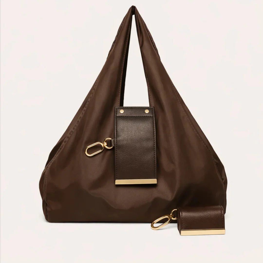 Brown handbag with gold accents on a light beige background