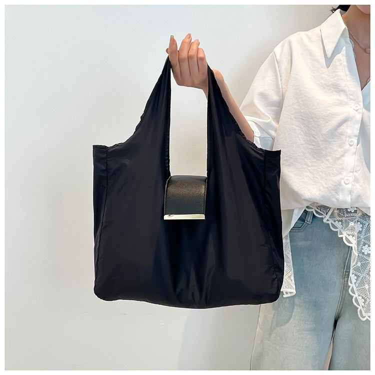 Person holding a black reusable bag with a white background