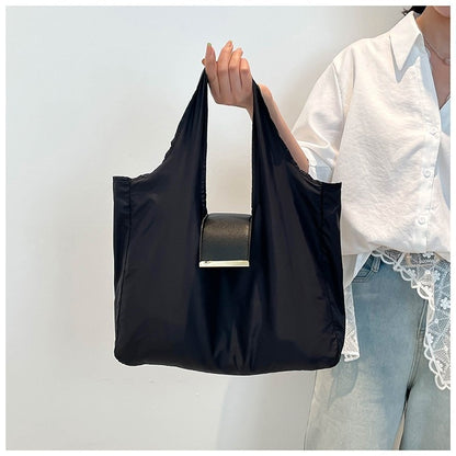 Person holding a black reusable bag with a white background