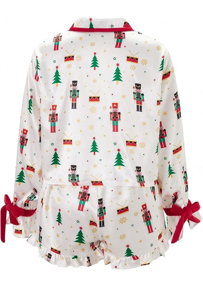 Christmas-themed baby romper with nutcrackers and trees on a white background
