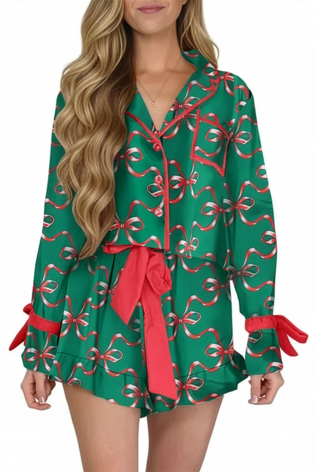 Green pajama set with red bows worn by a model on a white background