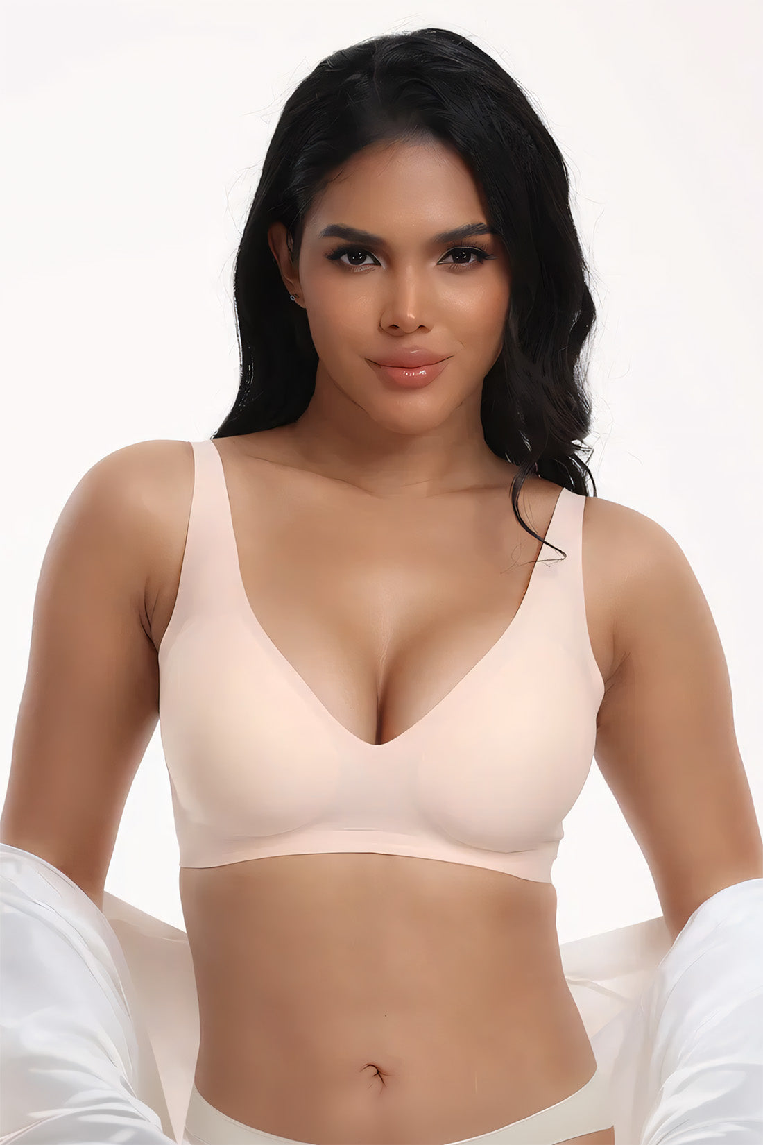 Woman wearing a beige bra against a white background