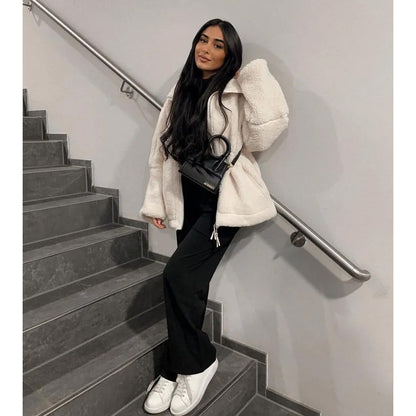 Woman in a white coat standing on a staircase