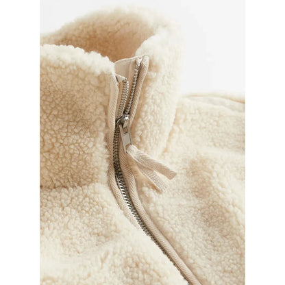 Close-up of a beige fleece jacket with a zipper on a white background