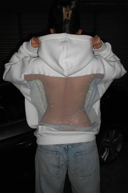 Person wearing a white hoodie with mesh panels over the chest area, standing in a dark setting.
